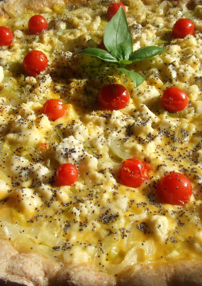 Una foto de Tarta de cebollas dulces, queso de cabra y tomatitos con semillas de amapola