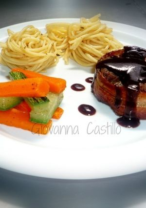 A picture of Beef Tenderloin Medallions Wrapped in Bacon with Red Wine Sauce.