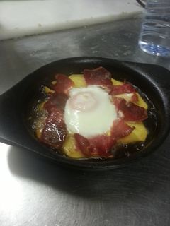 Una foto de Patatas ibéricas con huevo a caballo