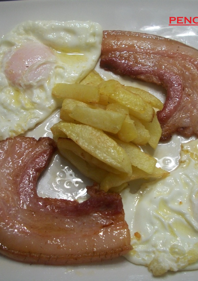 Una foto de Panceta ibérica adobada con huevos fritos