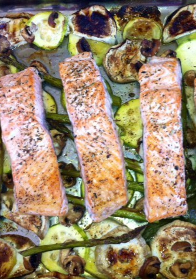 Una foto de Salmón al horno sobre espárragos verdes y calabacín