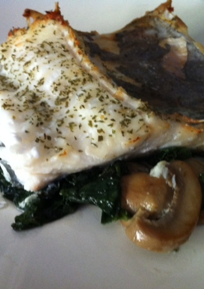 Una foto de Bacalao al horno sobre espinacas y champiñones salteados