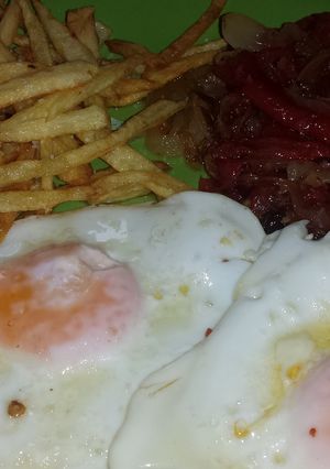 Una foto de Huevos fritos con pimientos y cebolla