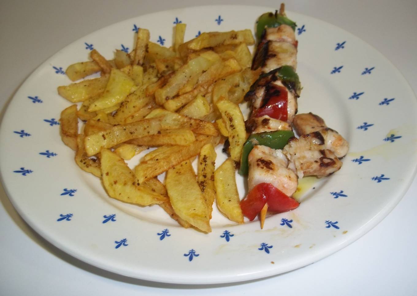 Pinchos de pollo y verduras con patatas fritas<br />