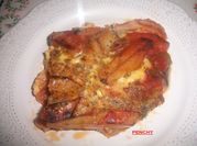 Una foto de filetes de cerdo con tomate