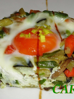 Una foto de Timbal de salteado de verduras y huevo escalfado