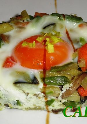 Una foto de Timbal de salteado de verduras y huevo escalfado