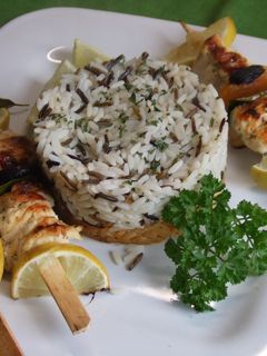 Una foto de Brochetas de pollo con frutas secas, arroces y repollo dorado