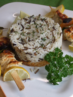 Una foto de Brochetas de pollo con frutas secas, arroces y repollo dorado