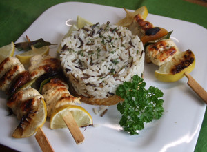 Una foto de Brochetas de pollo con frutas secas, arroces y repollo dorado