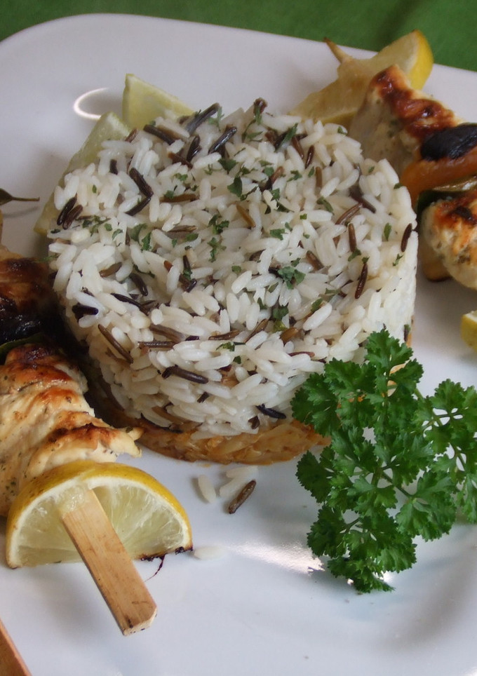 Una foto de Brochetas de pollo con frutas secas, arroces y repollo dorado