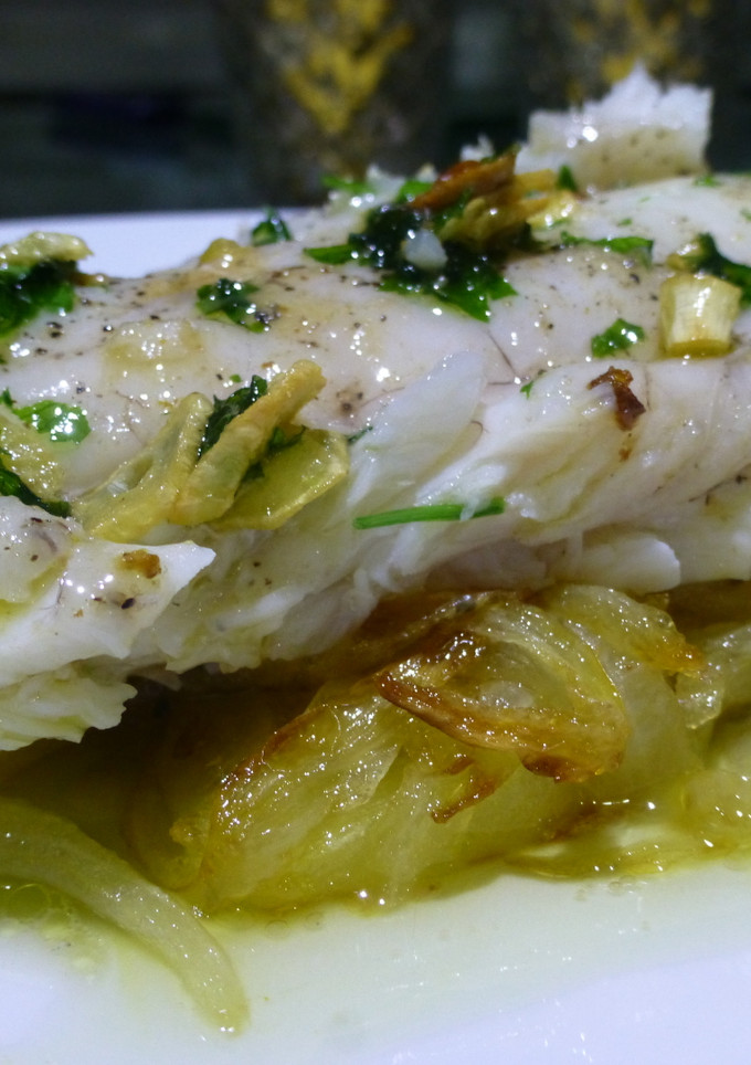 Una foto de Cogote de merluza sobre cama de patatas y cebolla