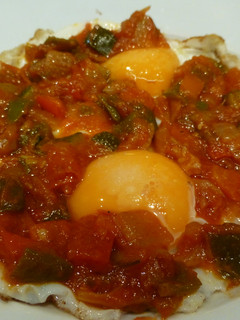 Una foto de Huevos fritos con tomate, calabacín y cebolla