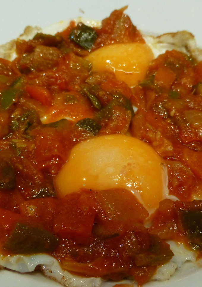 Una foto de Huevos fritos con tomate, calabacín y cebolla