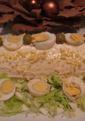 Una foto de Arrollado de pionono con crema de pollo, huevos y aceitunas