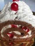Arrollado de chocolate con chantillí y cerezas