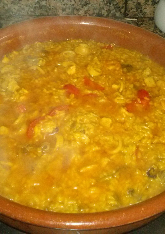 Una foto de Paella con pollo, gambas, calamares y almejas