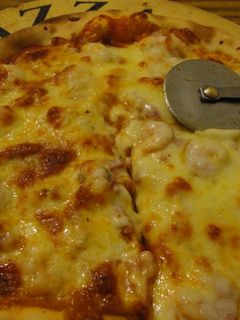 Una foto de Pizza invertida de bacon y gambas