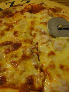 Una foto de Pizza invertida de bacon y gambas