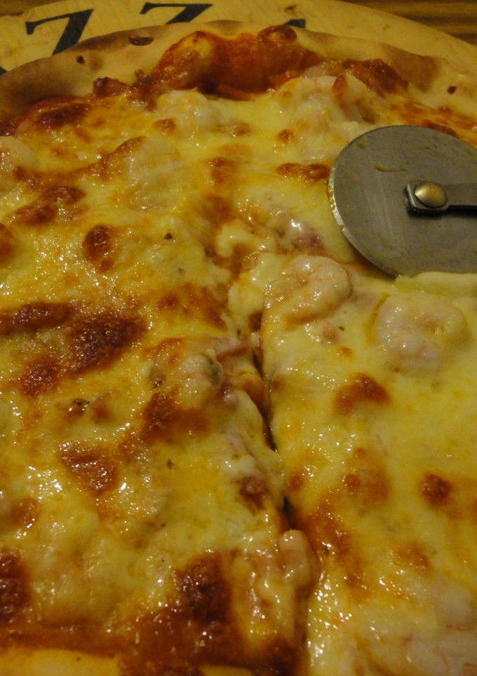 Una foto de Pizza invertida de bacon y gambas