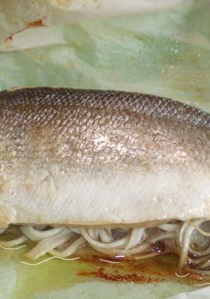 Una foto de Lubina rellena de gulas y gambitas en papillote