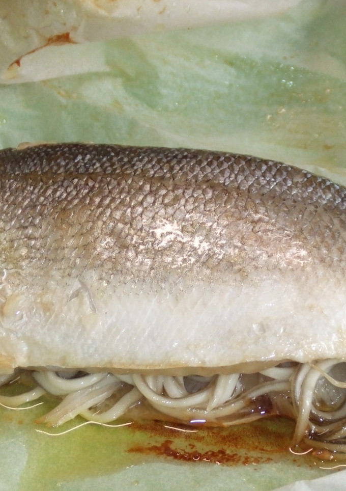Una foto de Lubina rellena de gulas y gambitas en papillote