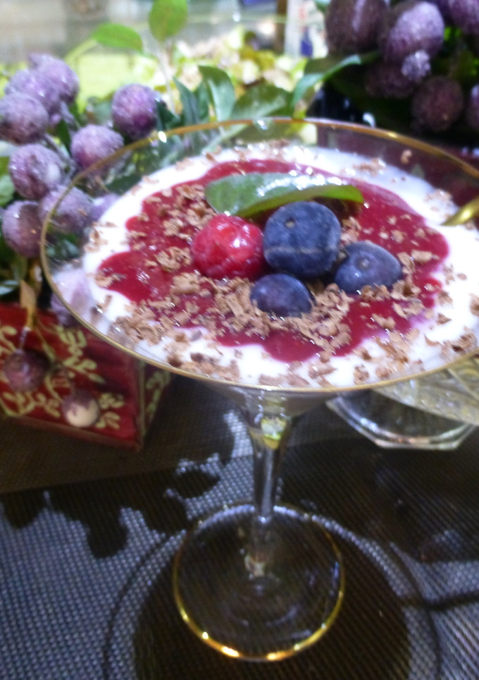 Una foto de Postre yogur con salsa de frambuesas y arándanos