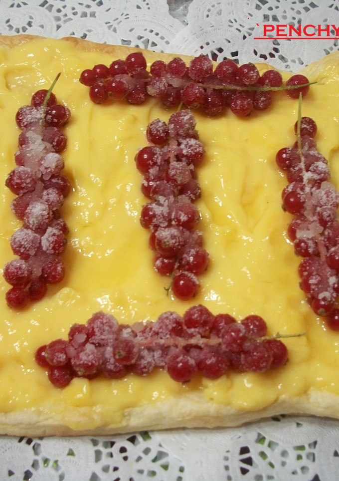 Una foto de Tarta de crema pastelera con grosellas silvestres escarchadas