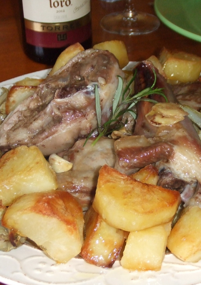 Una foto de Cordero al horno con patatas asadas y alcachofas