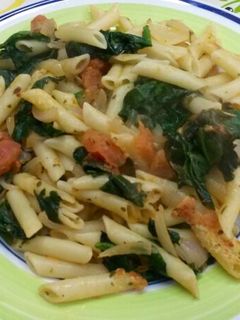 Una foto de Macarrones con espinacas y tomate fresco