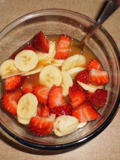 Una foto de Macedonia de fresas y plátano con zumo de naranja
