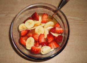 Una foto de Macedonia de fresas y plátano con zumo de naranja