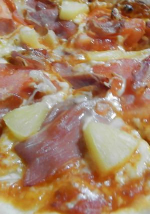 Una foto de Pizza de tomate, jamón serrano y piña