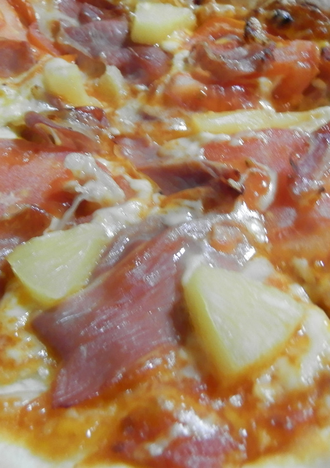 Una foto de Pizza de tomate, jamón serrano y piña