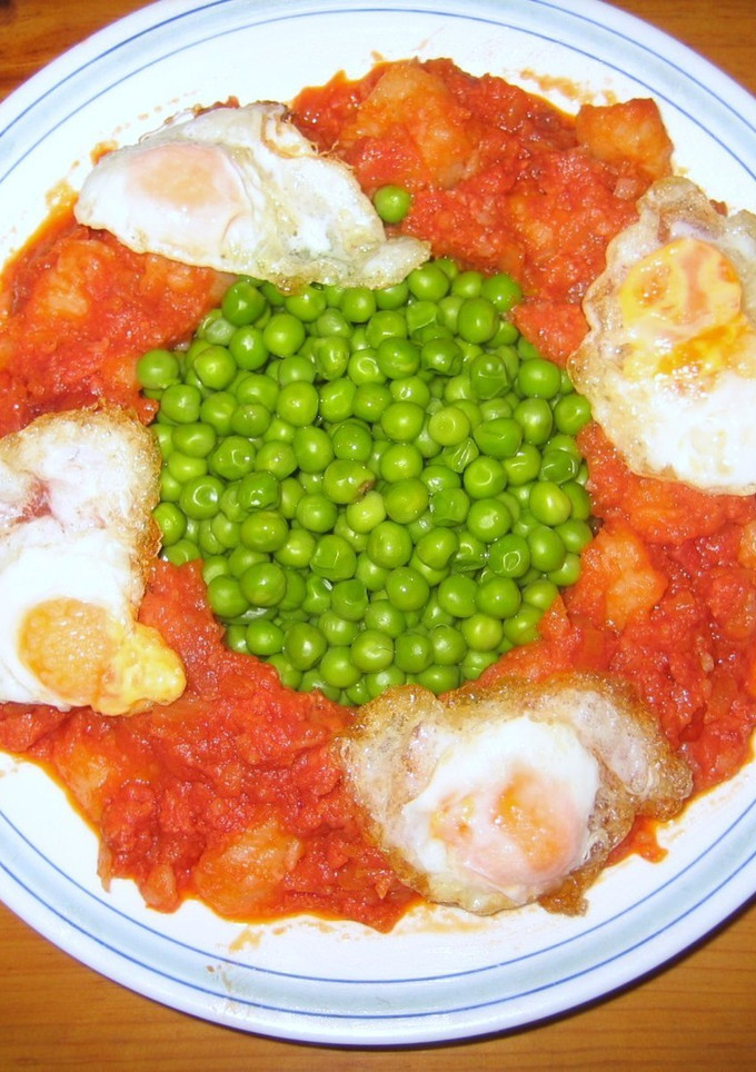 Una foto de Huevos con patatas, jamón serrano, chorizo y guisantes