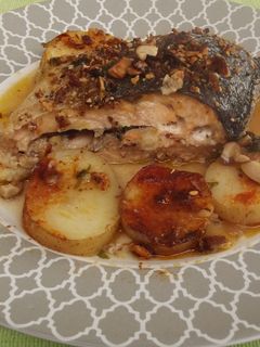 Una foto de Salmón entero con almendras y patatas