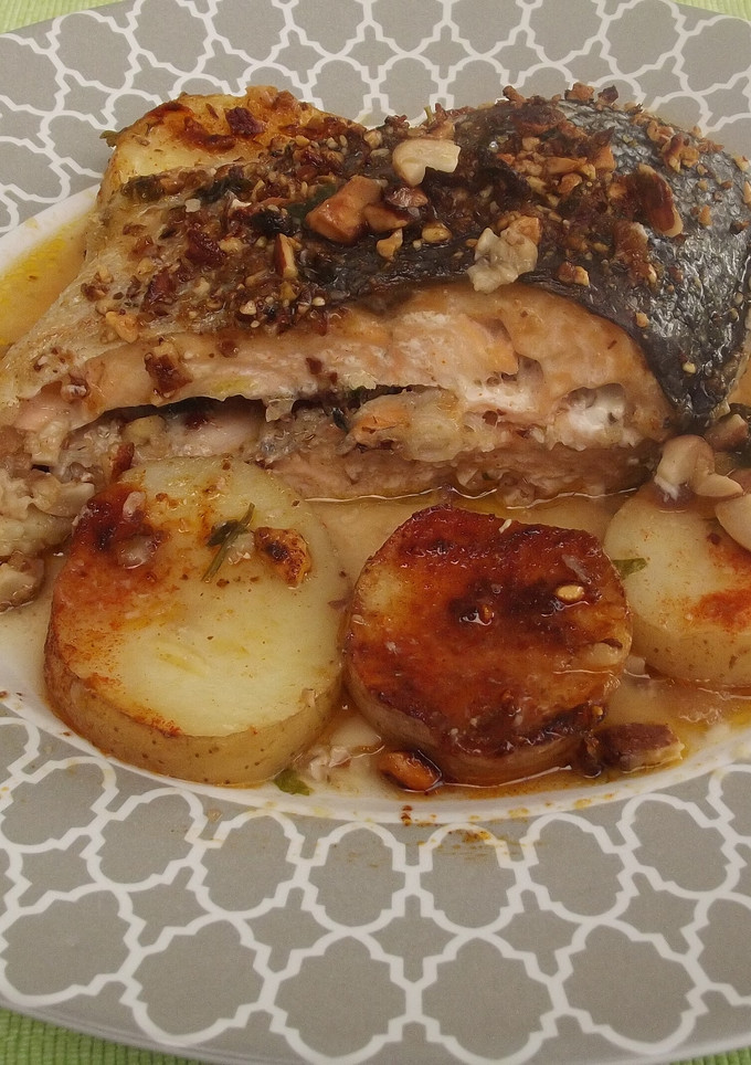 Una foto de Salmón entero con almendras y patatas