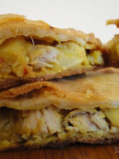 Una foto de Empanada crujiente de pollo y patatas fritas