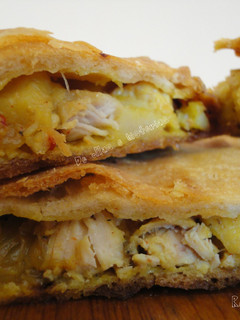 Una foto de Empanada crujiente de pollo y patatas fritas