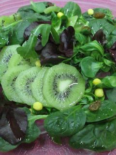 Una foto de Ensalada verde con brotes de lechugas y kiwis