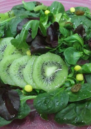 Una foto de Ensalada verde con brotes de lechugas y kiwis