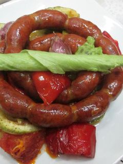 Una foto de Mini chorizos colorados con variado de verduras al horno