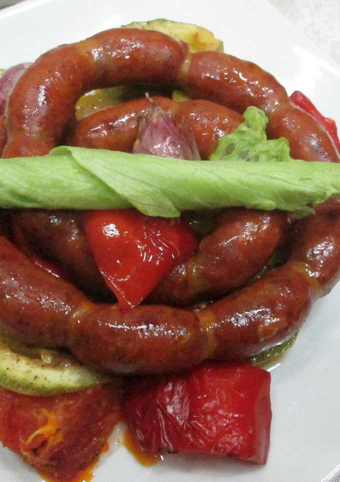 Una foto de Mini chorizos colorados con variado de verduras al horno