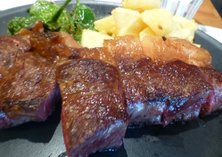 Chuletón con pimientos y patatas fritas