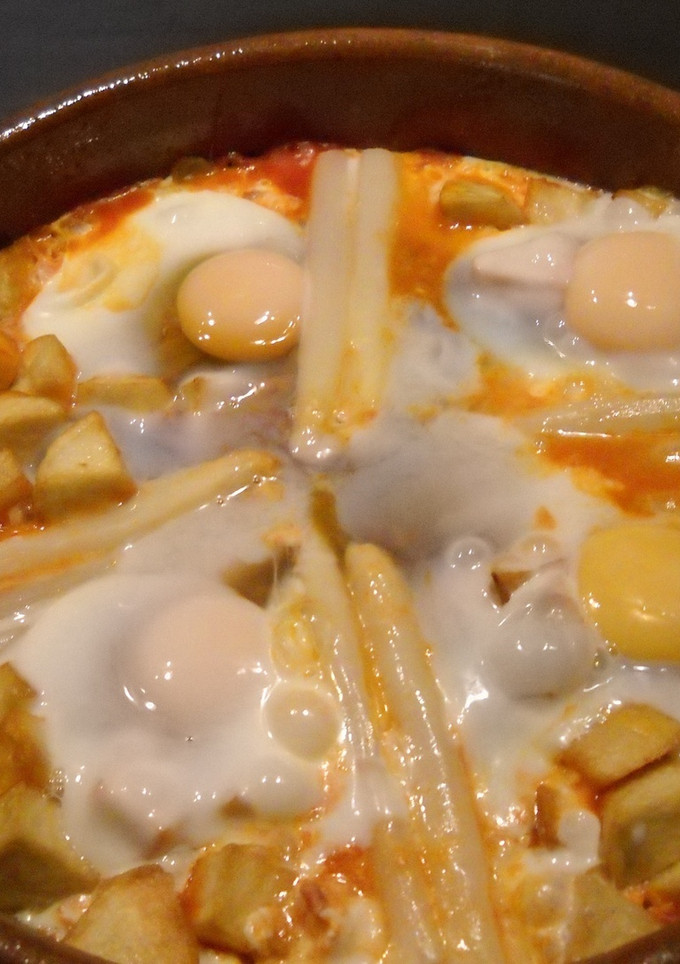 Una foto de Huevos a la flamenca con judias, guisantes, chorizo y jamón serrano