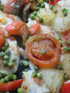 Una foto de Merluza al horno cubierta de vegetales
