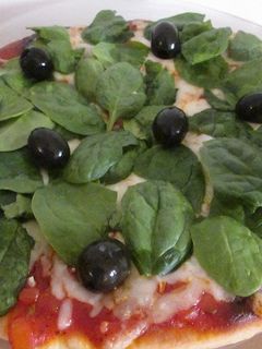 Una foto de Pizza con espinacas frescas