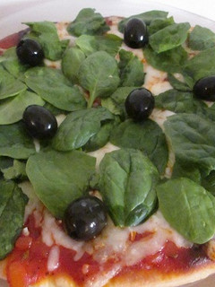Una foto de Pizza con espinacas frescas