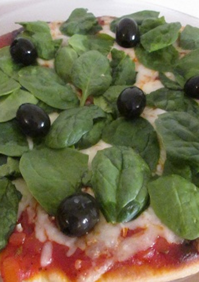 Una foto de Pizza con espinacas frescas