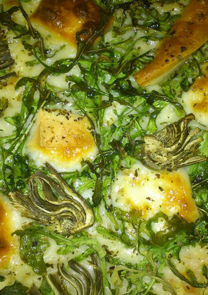 Una foto de Pizza de rúcula, alcachofa y queso